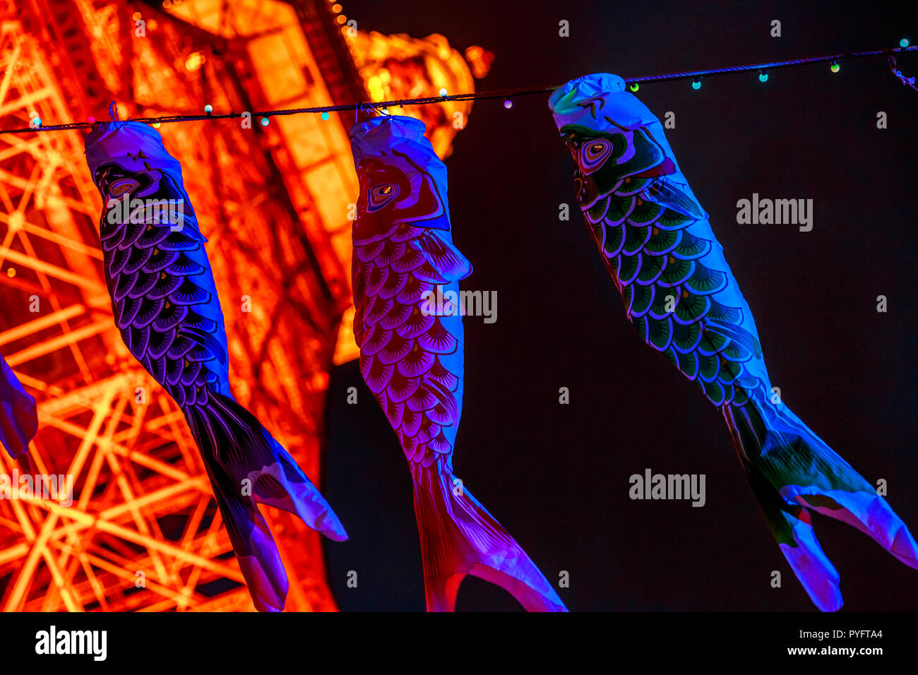 Tokyo, Japon - 23 Avril 2017 : une carpe Koinobori bleu en forme de chaussettes du vent, traditionnellement utilisé au Japon pour célébrer la Journée de l'enfance. La Tour de Tokyo par nuit brouillée sur arrière-plan. Plan horizontal Banque D'Images