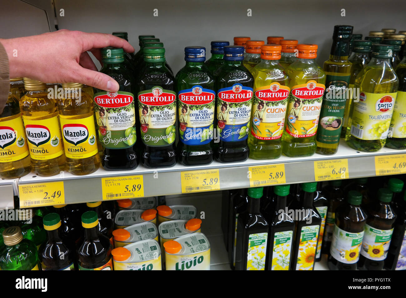 Diverses huiles de cuisson bouteille, comme l'huile d'olive, sont affichés dans une étagère de supermarché Banque D'Images