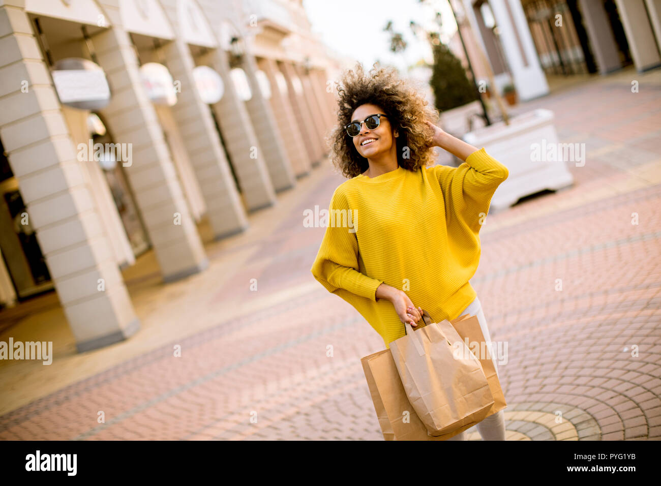 Jolie jeune femme noire avec les cheveux bouclés shopping Banque D'Images