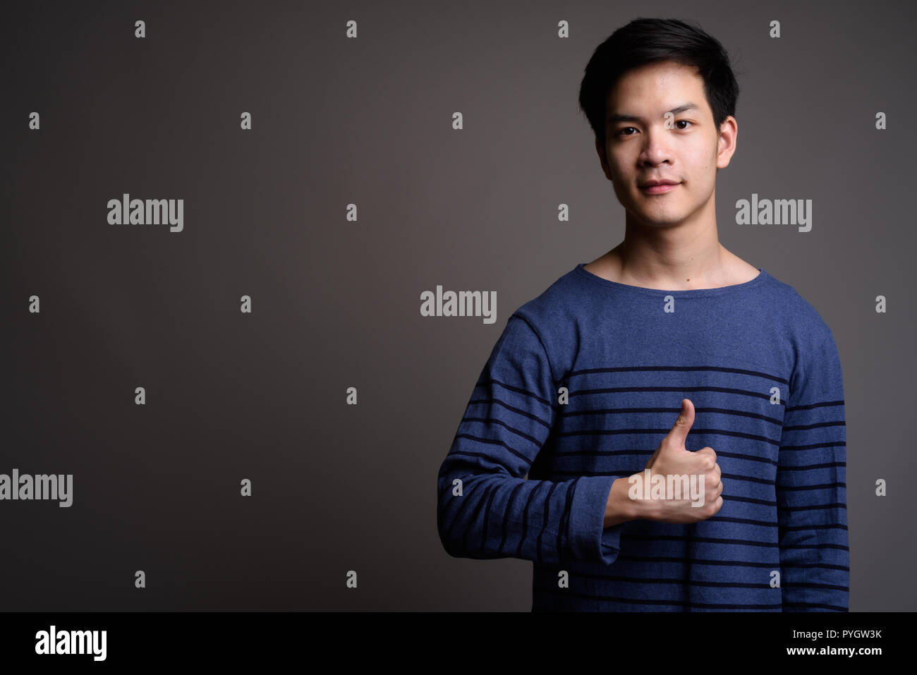 Young handsome Asian man giving thumb up Banque D'Images