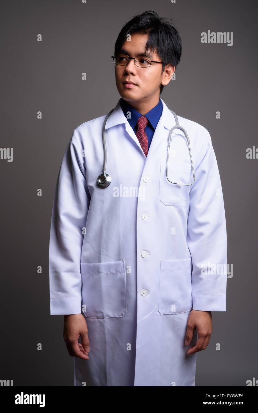 Portrait of young Asian man looking up et pensée médecin Banque D'Images