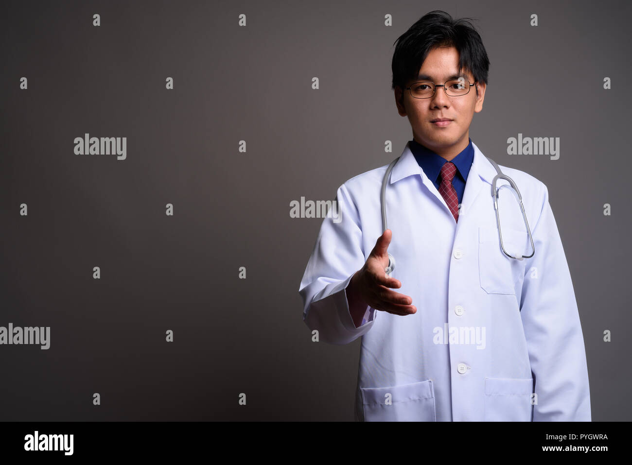Portrait of young Asian man doctor giving handshake Banque D'Images