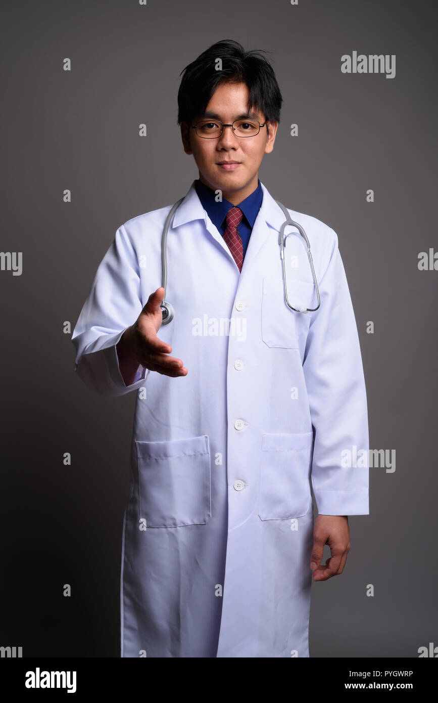 Portrait of young Asian man doctor giving handshake Banque D'Images