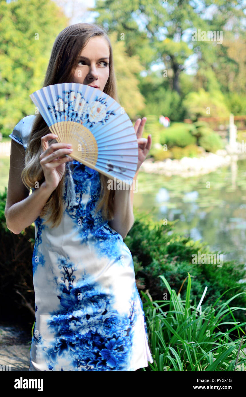 Modèle des Femmes de Pologne portant robe chinoise traditionnelle dans des  couleurs bleues et blanches avec des fleurs. Woman posing in parc de style  asiatique Photo Stock - Alamy