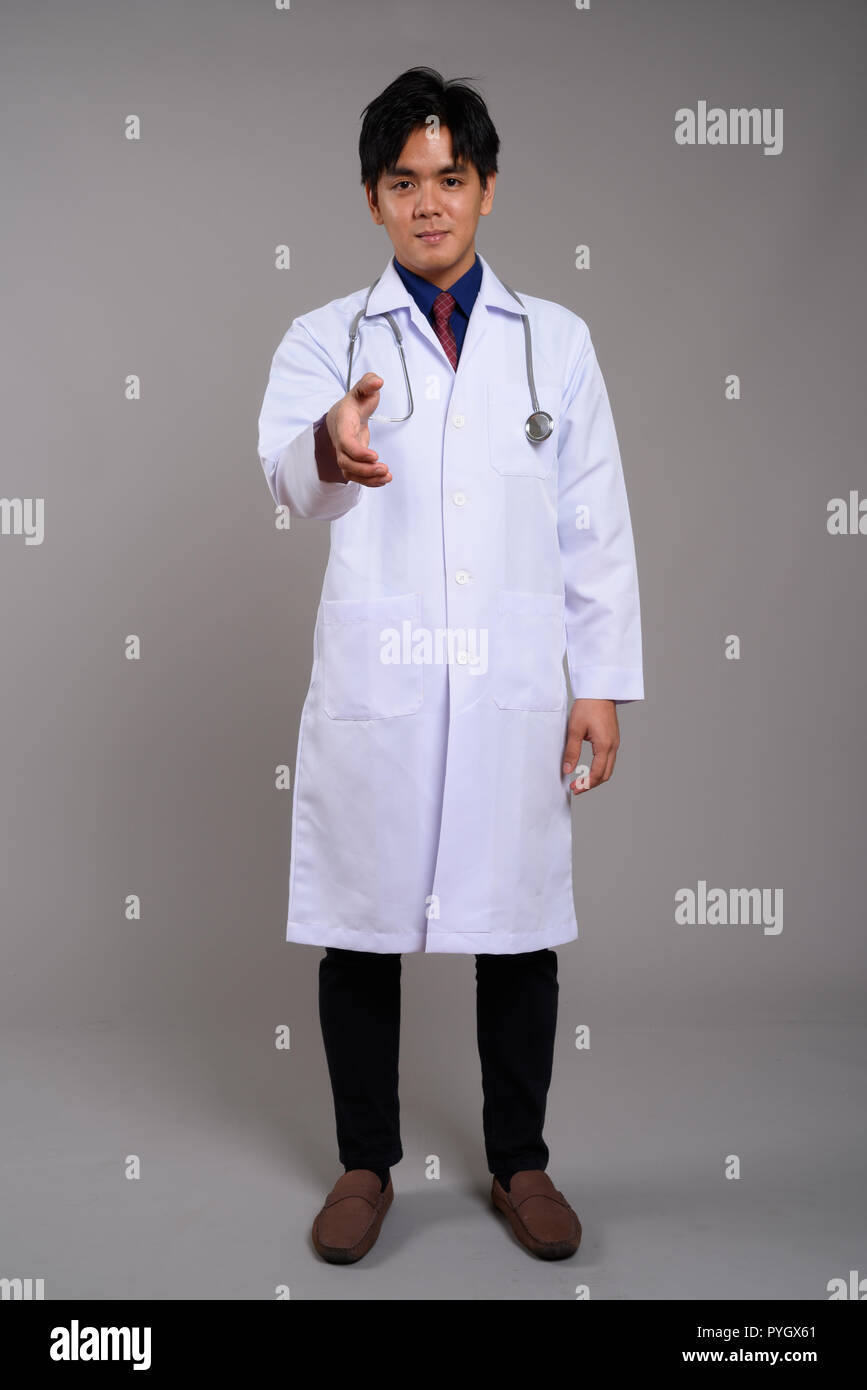 Full Length portrait of young Asian man doctor giving handshake Banque D'Images
