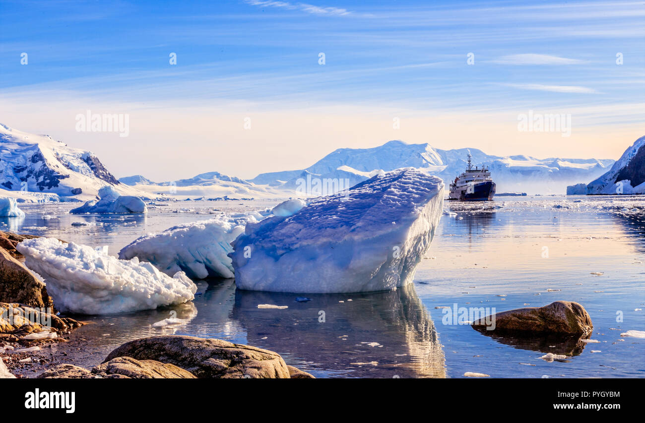 Bateau de croisière antarctique touristiques parmi les icebergs avec glacier en arrière-plan, la baie de Neco, Antarctique Banque D'Images