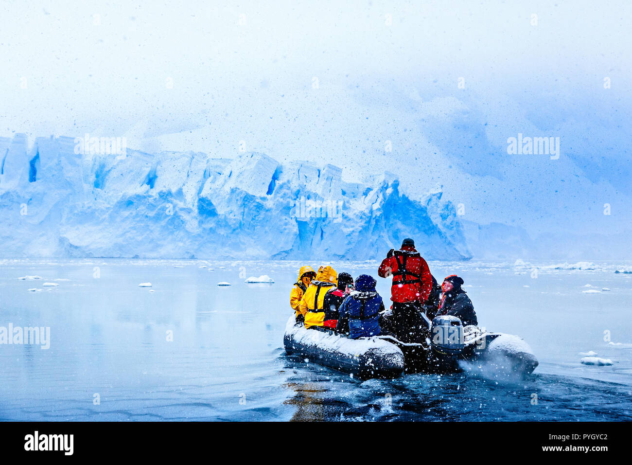 Neige dans le bateau avec les touristes en route vers le glacier bleu énorme mur dans l'arrière-plan, près de l'Almirante Brown, péninsule antarctique Banque D'Images