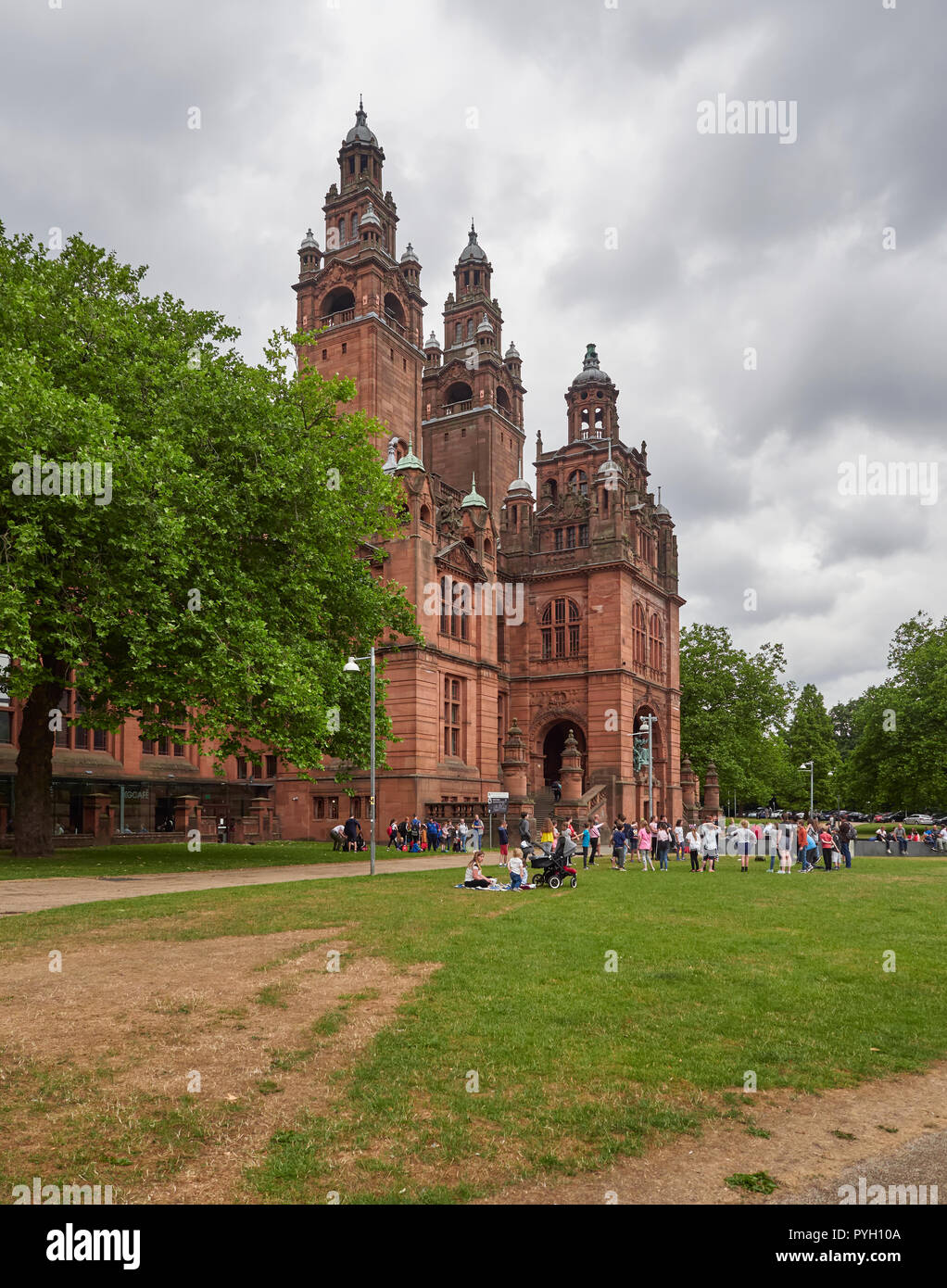 Profitant de la chaleur de l'été Glaswegians dans l'herbe à l'extérieur de l'entrée du musée de Kelvingrove à Glasgow, Écosse, Royaume-Uni. Banque D'Images