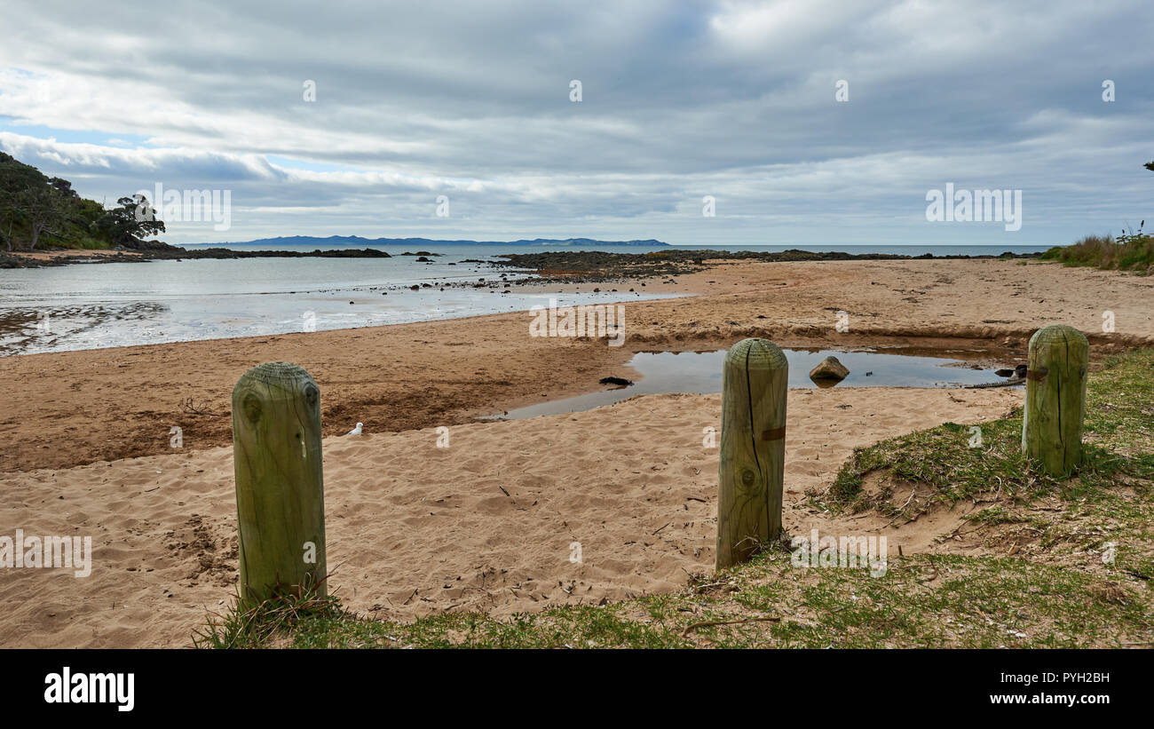 Bornes en bois pour empêcher l'accès des véhicules à la plage de la baie de câble en Nouvelle-Zélande mangonui Banque D'Images