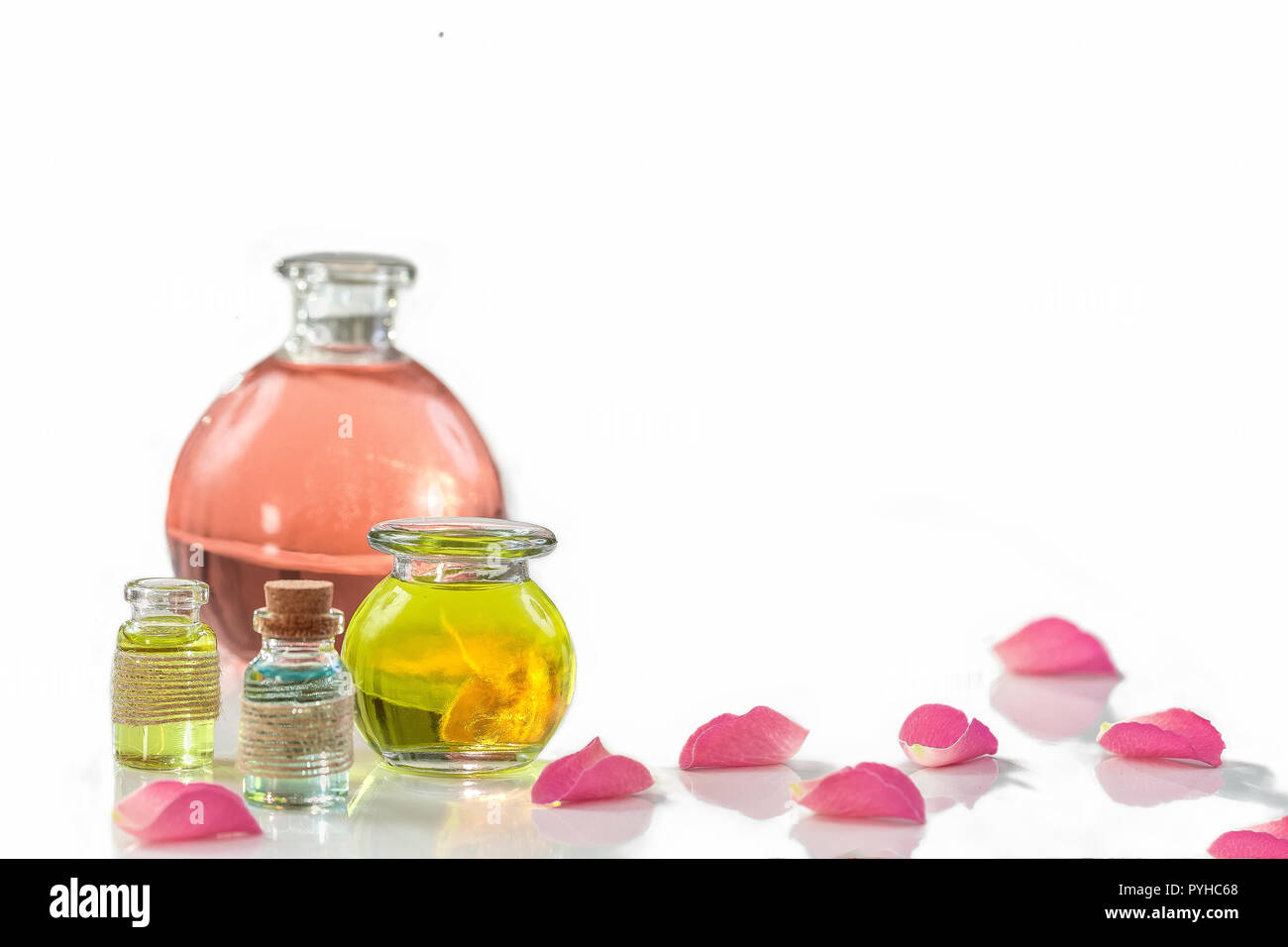 Des pétales de rose avec aromathérapie huiles essentielles le flacon en verre isolated over white , fond, copy-space Banque D'Images