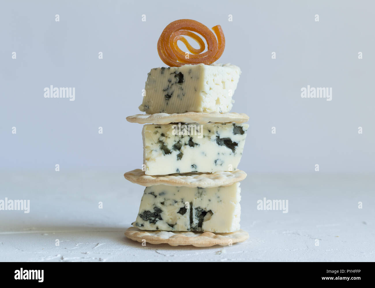 Cubes de fromage bleu sur des craquelins pile close up side view photo sur fond texturé Banque D'Images