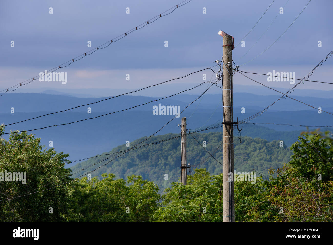 Le paysage bulgare avec les câbles électriques suspendus dans toutes les directions à partir d'un vieux pilier en béton. Région de montagne Strandja Banque D'Images