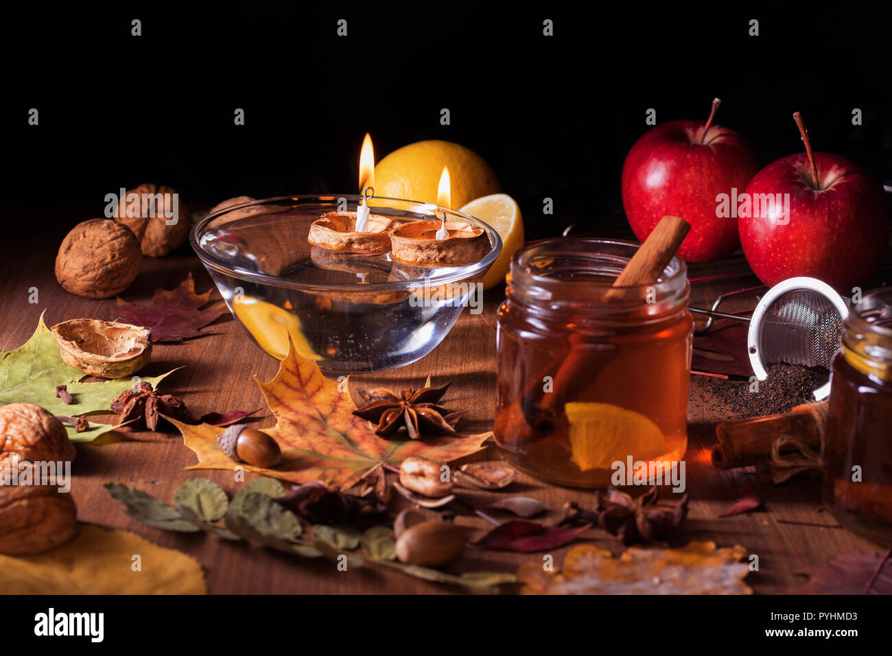 Table en bois foncé avec 2 verres de thé avec l'automne, automne décoration et foncé, fond noir. Les feuilles colorées, citron, cannelle, noix, pommes, t Banque D'Images
