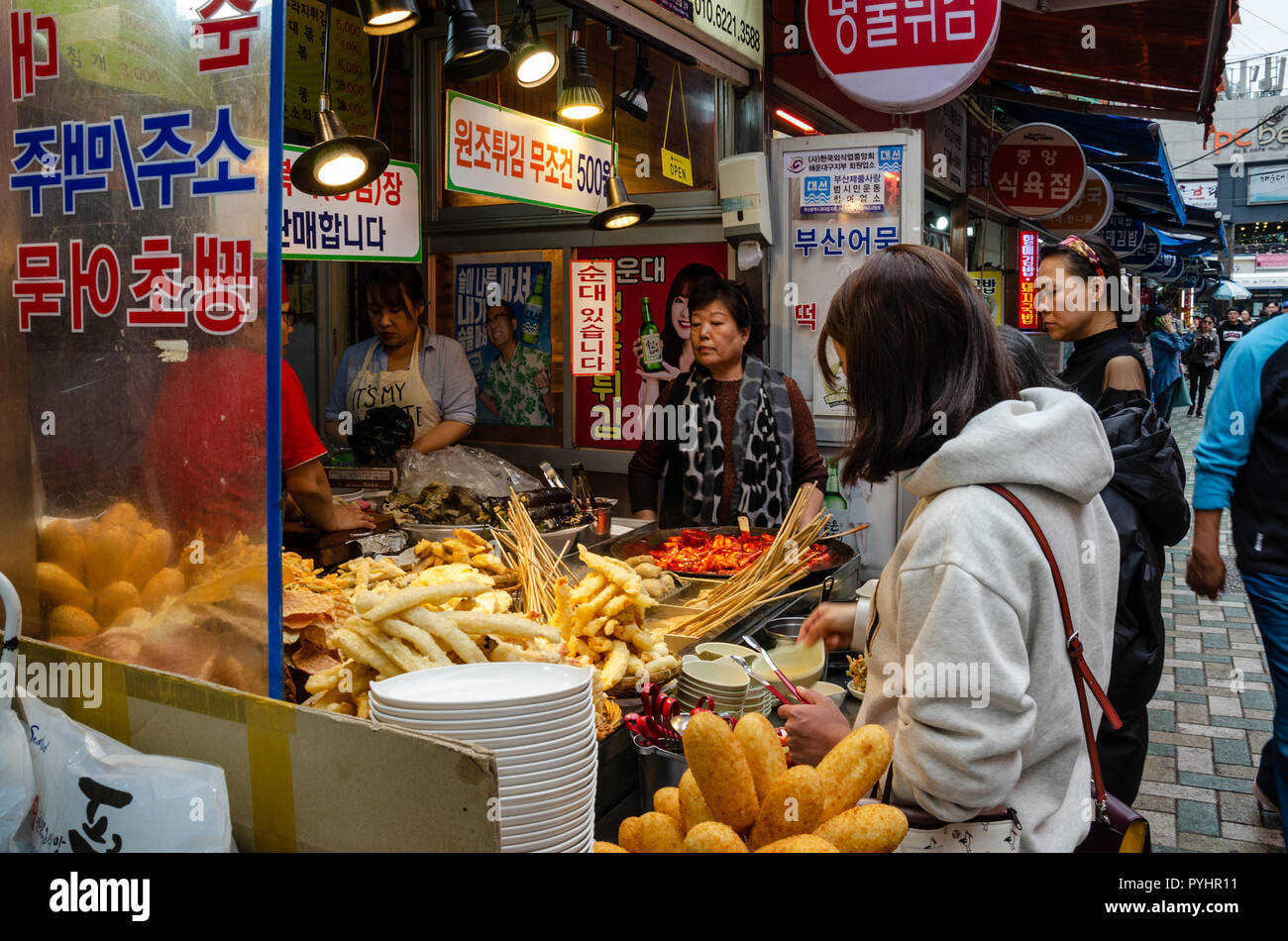 Les clients d'acheter de la nourriture et des collations à partir d'un vendeur dans l'alimentation de rue Marché de Haeundae, Haeundae de Busan, Corée du Sud. Banque D'Images