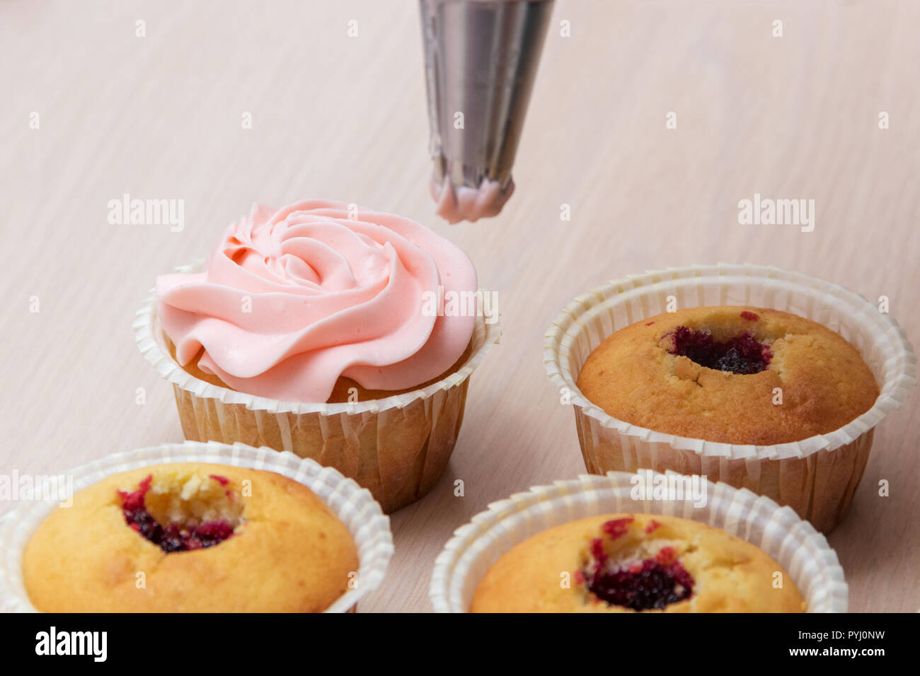 L'application de la crème sur les cupcakes Banque D'Images