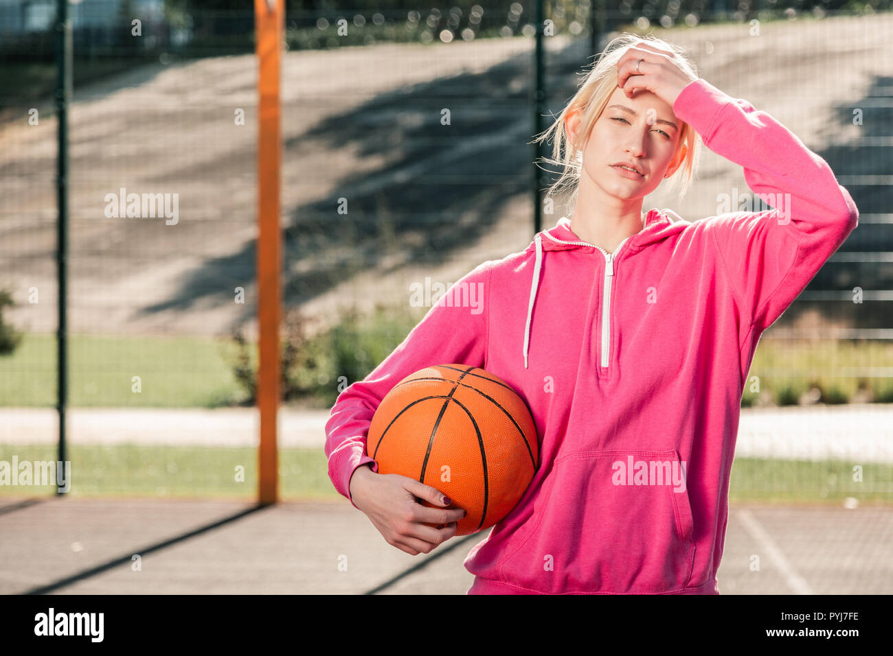 Beau jeune blond woman wearing sportswear rose Banque D'Images
