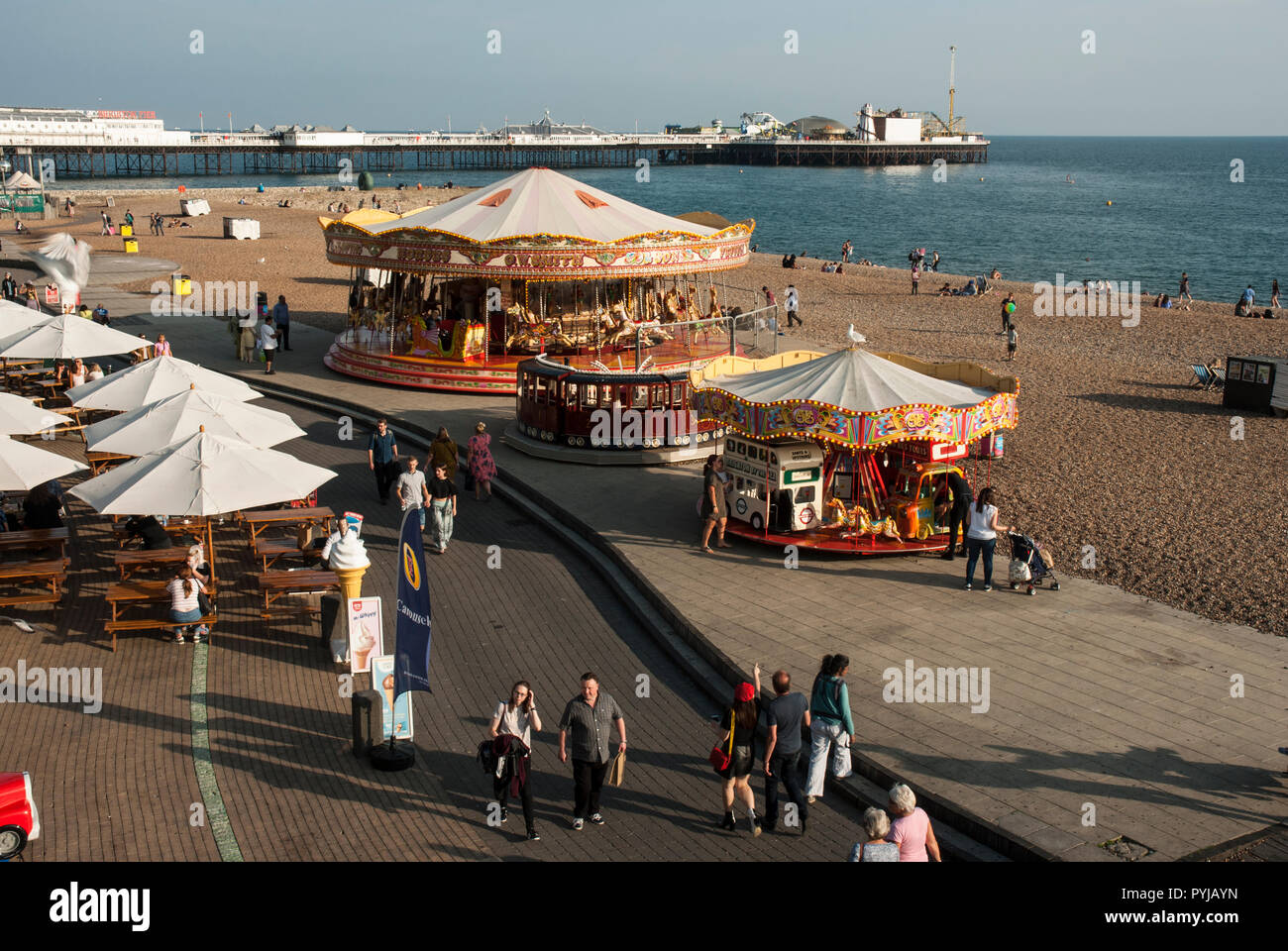 Vue de la promenade de Brighton avec les vacanciers profitant du soleil et des manèges. Banque D'Images