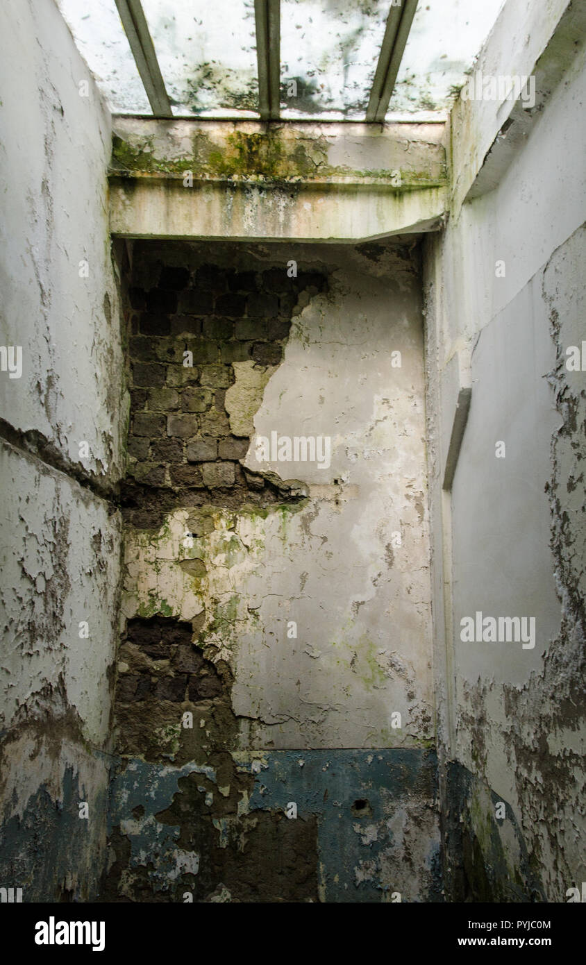 Hall abandonné avec baies vitrées - claire lumière montrent les ruines de murs avec la chute de plâtre Banque D'Images