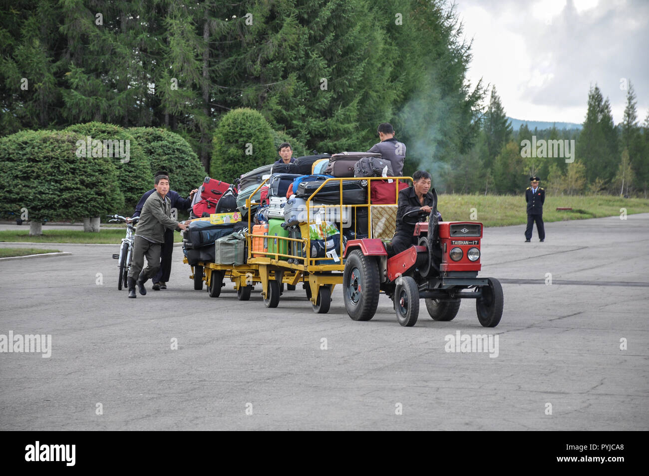 09/01/2018, Samjiyong, North-Korea : Assurance à partir d'un avion russe IL-18 est transporté jusqu'à l'aérogare par un tiniy tracteur. L'agent de surveillance est Banque D'Images