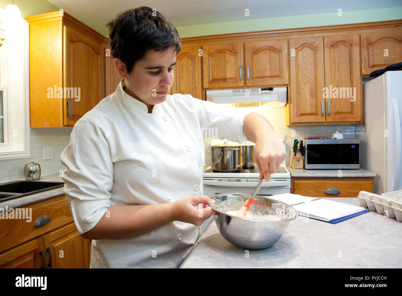 La cuisine dans la cuisine se mélange dans un bol en métal à l'aide d'une spatule Banque D'Images