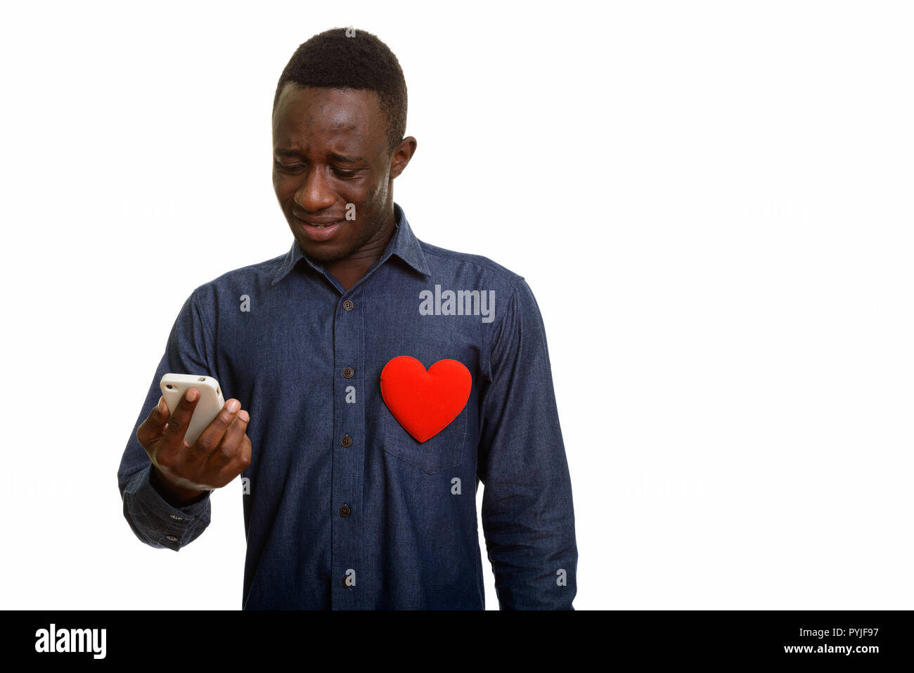Triste homme africain à l'aide de téléphone mobile avec cœur rouge sur la poitrine Banque D'Images