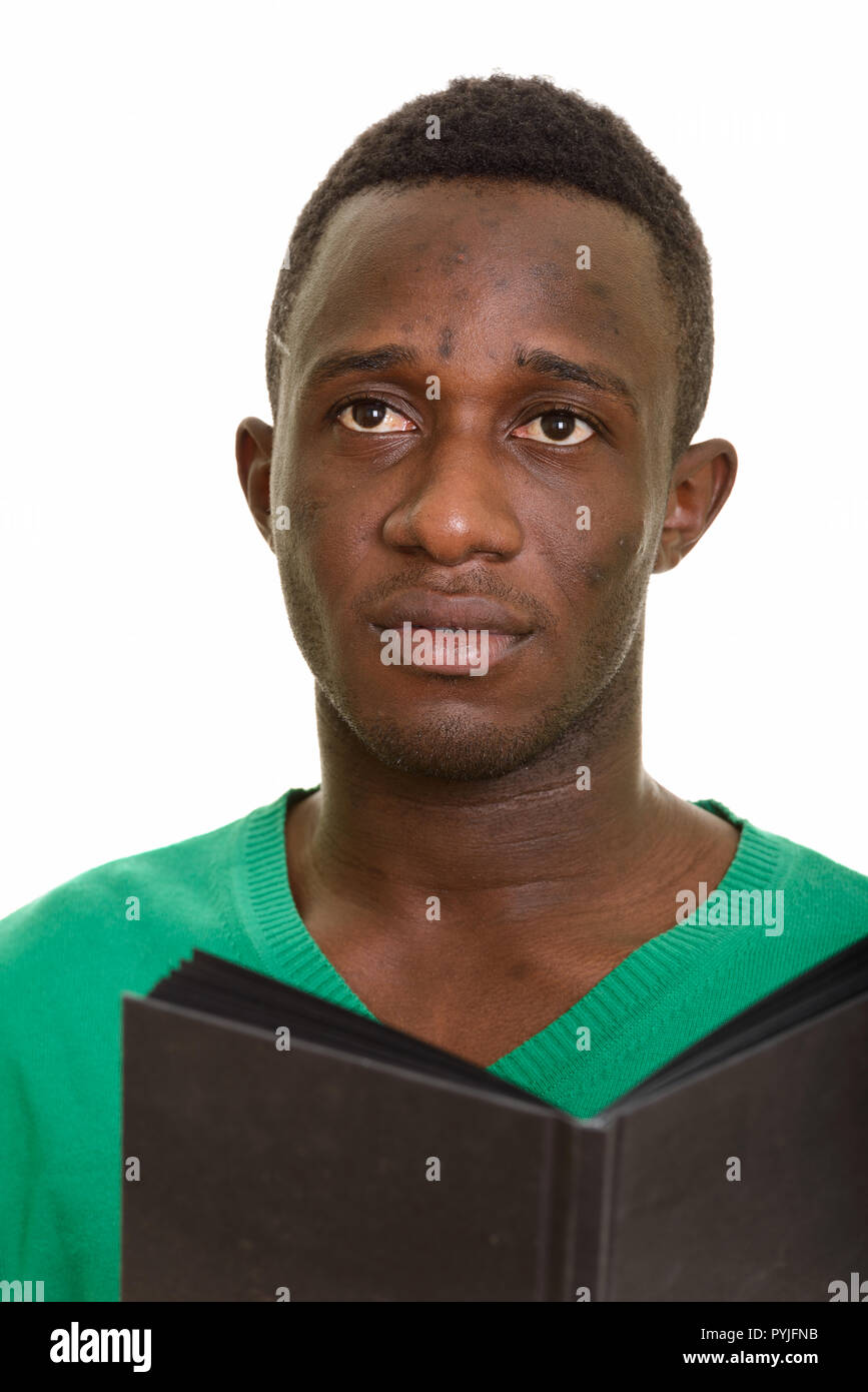 Handsome Young African man holding book en pensant Banque D'Images