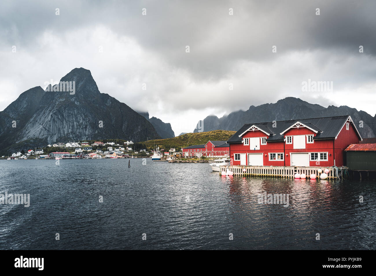 Paysage du village de pêche Reine avec la Reine Fjord pendant le coucher du soleil avec de belles lumières sur montagne, ciel bleu et nuages. Lofoten, Norvège. Photo prise Banque D'Images