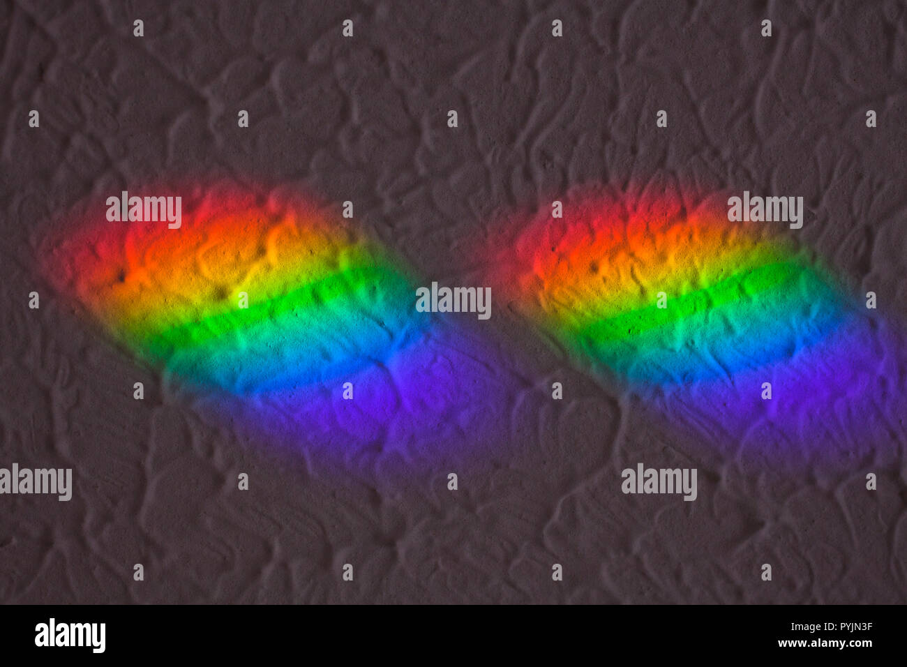 Couleurs arc-en-ciel sur le plafond, causée par la lumière du soleil passant à travers les petits prismes sur le rebord. "Couleur et texture'. Les prismes viennent de jumelles Banque D'Images