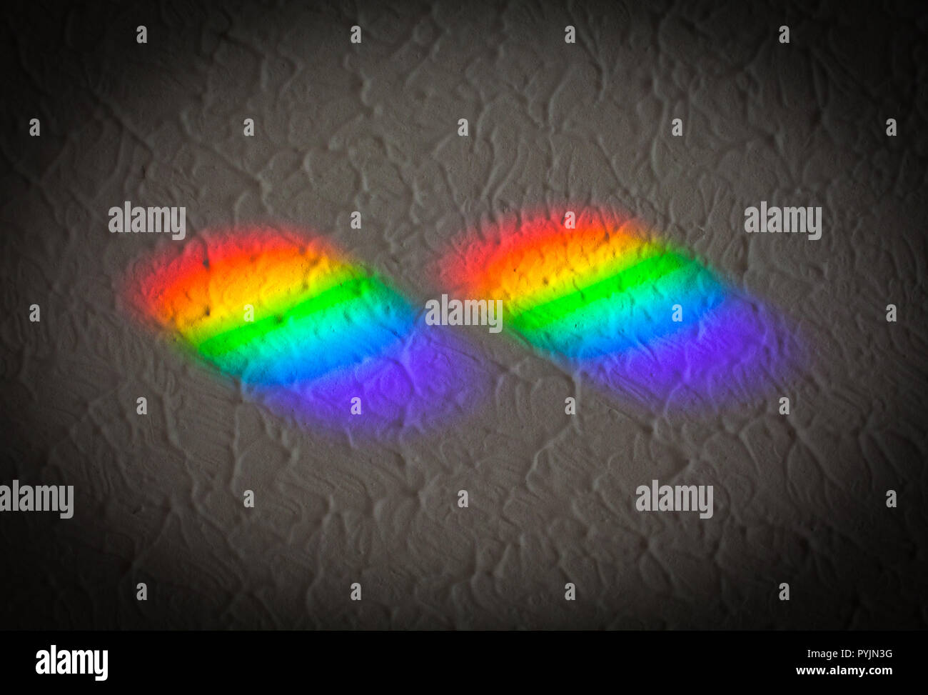 Couleurs arc-en-ciel sur le plafond, causée par la lumière du soleil passant à travers les petits prismes sur le rebord. "Couleur et texture'. Les prismes viennent de jumelles Banque D'Images