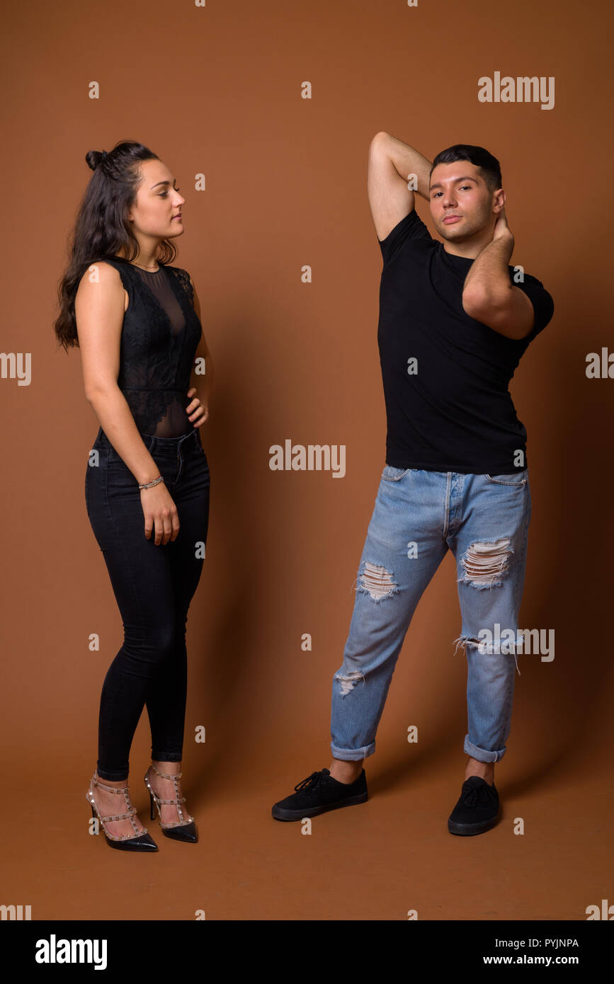 Jeune couple ensemble et dans l'amour contre fond brun Banque D'Images