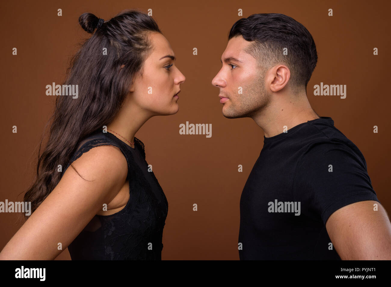 Jeune couple ensemble et dans l'amour contre fond brun Banque D'Images