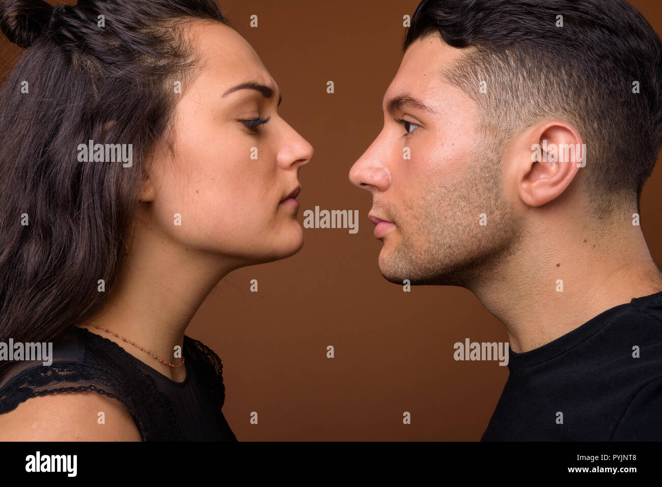 Jeune couple ensemble et dans l'amour contre fond brun Banque D'Images