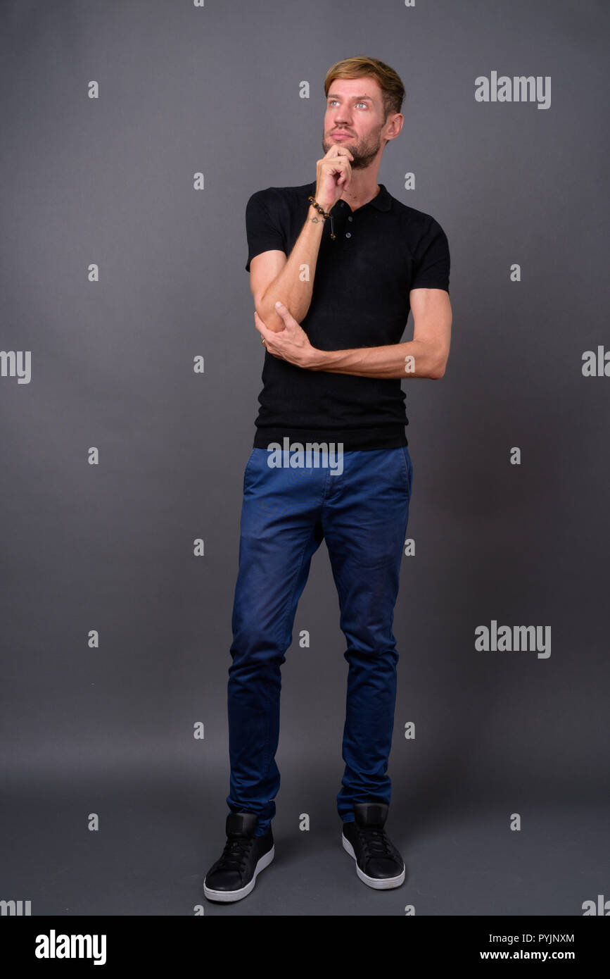 Portrait d'homme barbu blond contre l'arrière-plan gris Banque D'Images