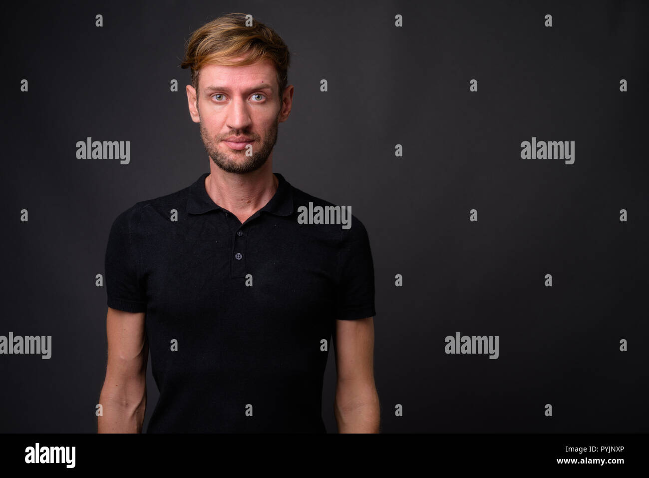 Portrait d'homme barbu blond contre l'arrière-plan gris Banque D'Images