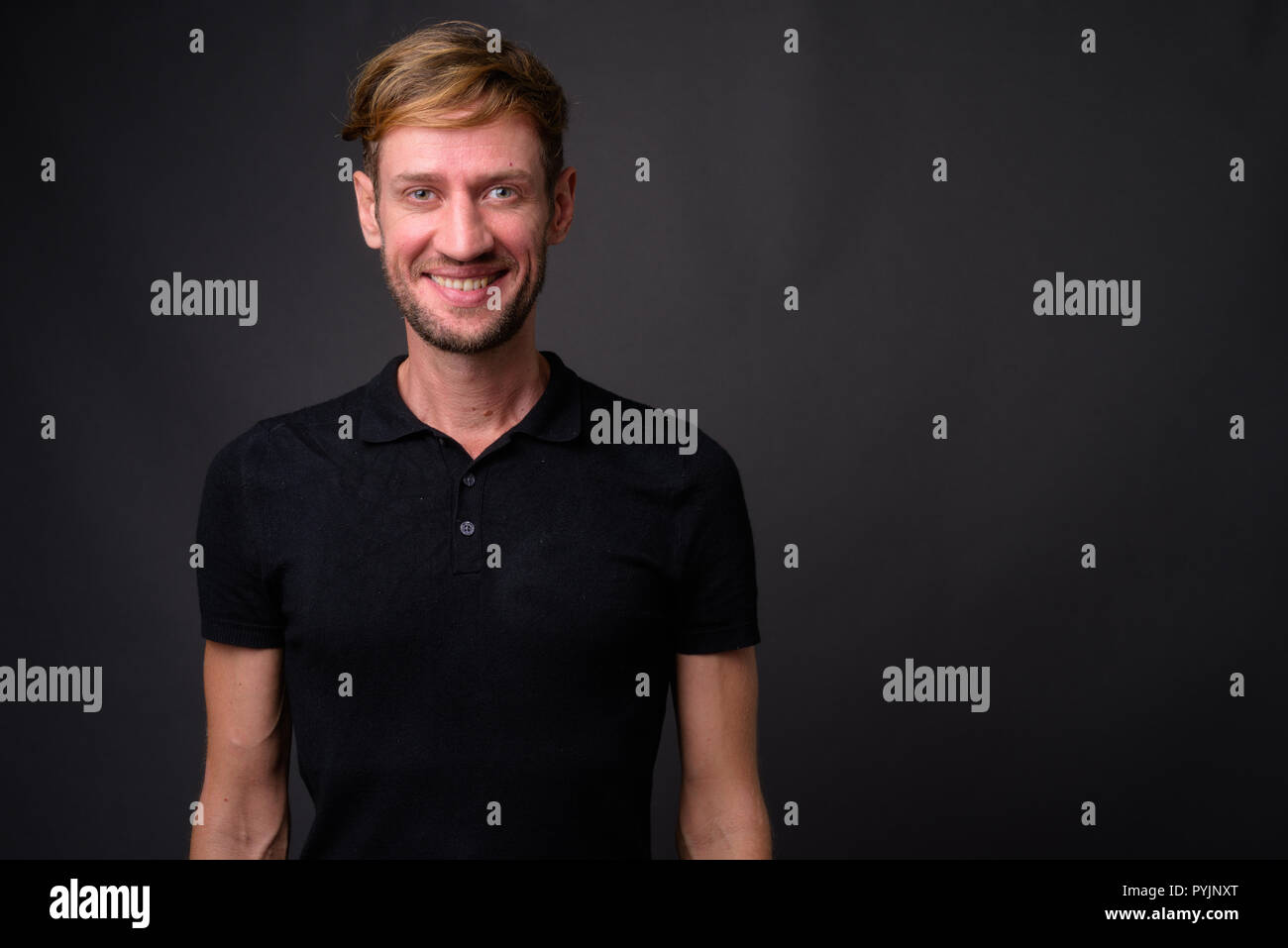 Portrait d'homme barbu blond contre l'arrière-plan gris Banque D'Images