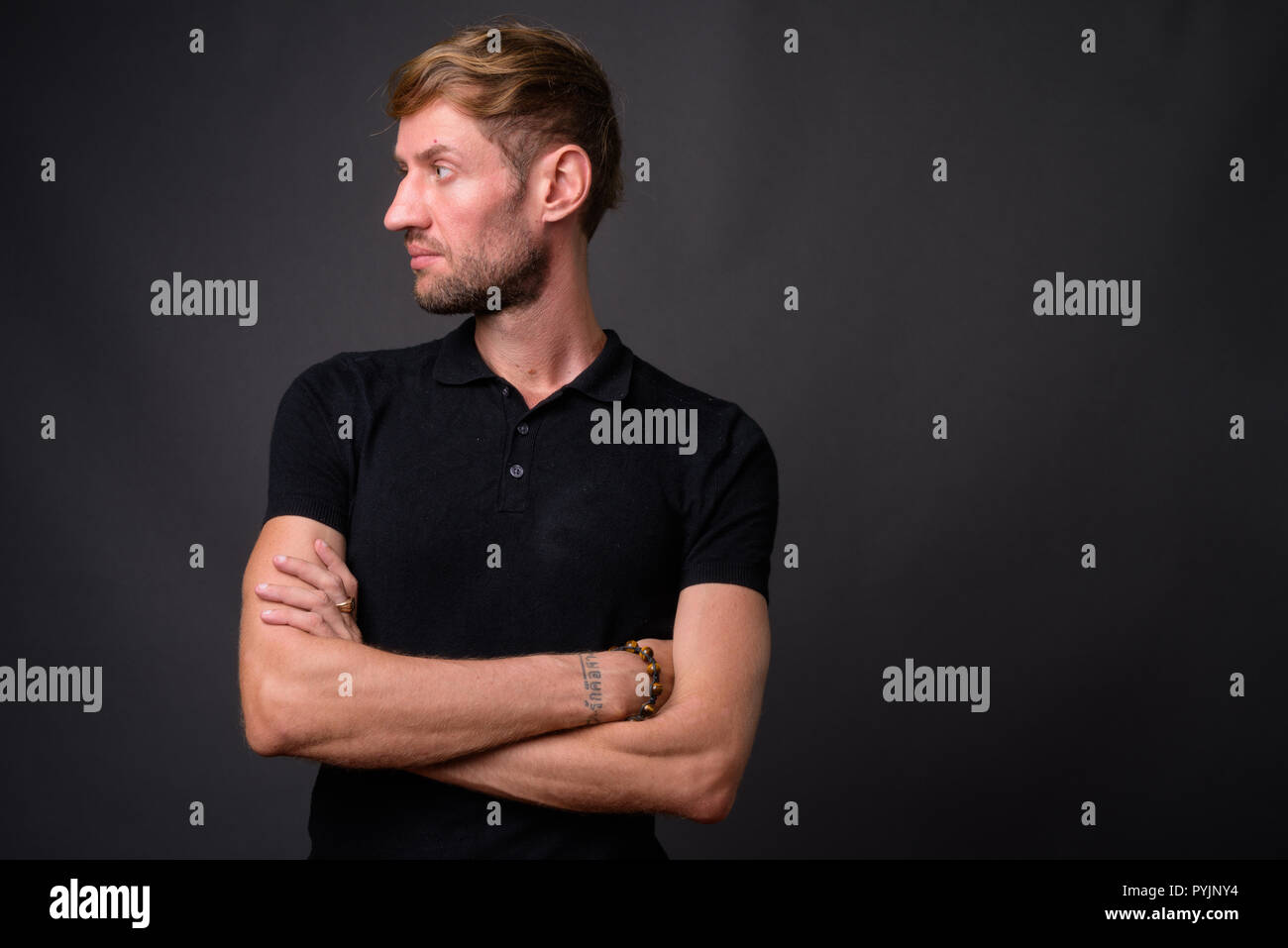 Portrait d'homme barbu blond contre l'arrière-plan gris Banque D'Images