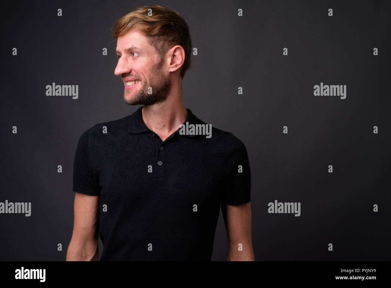 Portrait d'homme barbu blond contre l'arrière-plan gris Banque D'Images