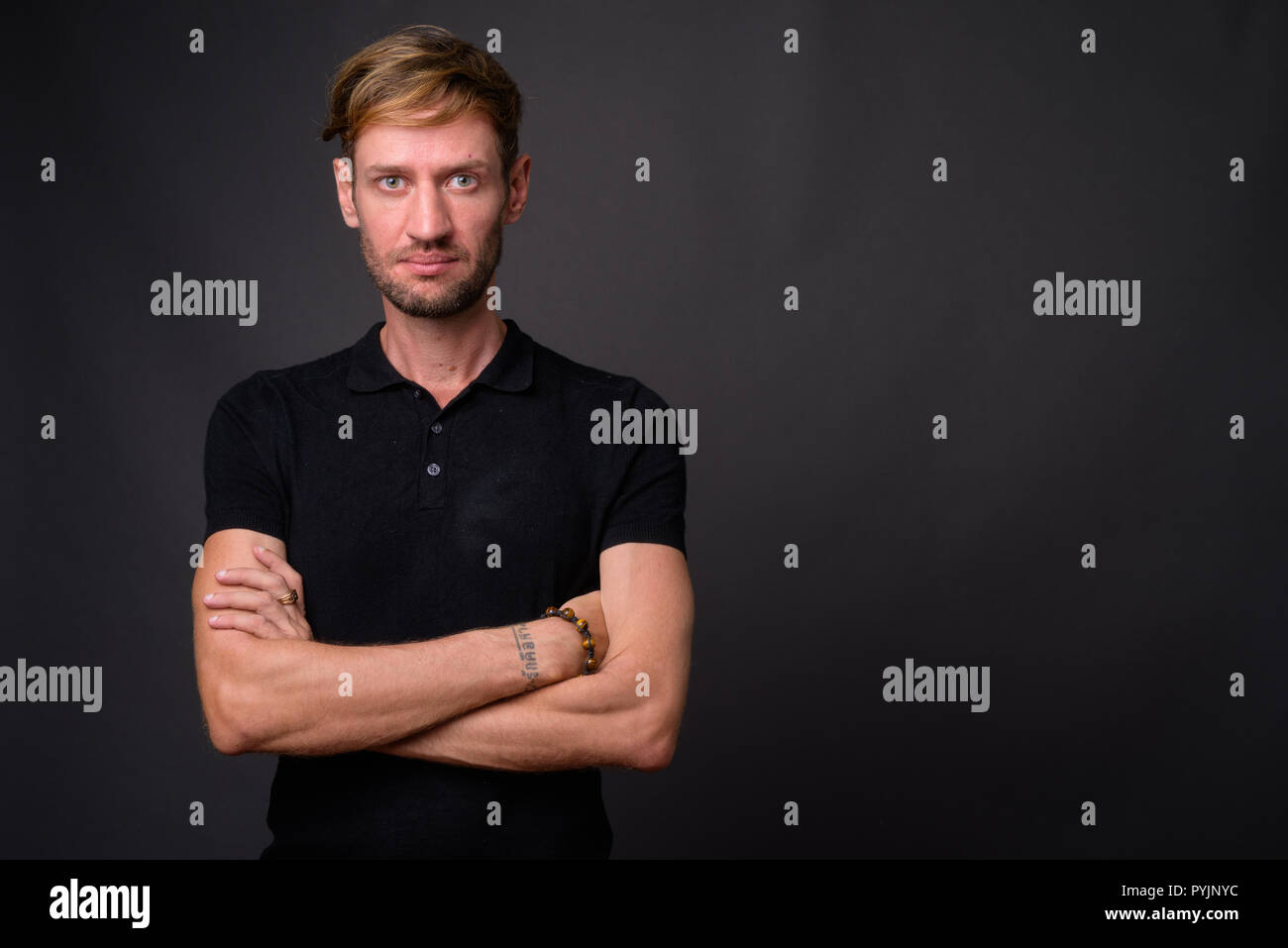 Portrait d'homme barbu blond contre l'arrière-plan gris Banque D'Images