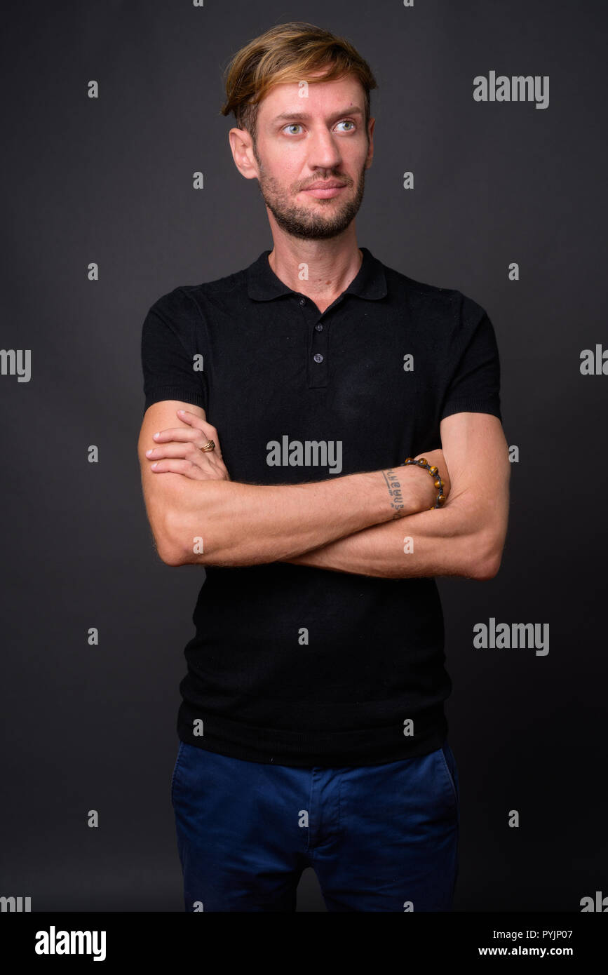 Portrait d'homme barbu blond contre l'arrière-plan gris Banque D'Images