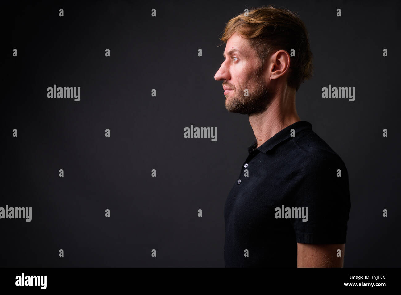 Portrait d'homme barbu blond contre l'arrière-plan gris Banque D'Images