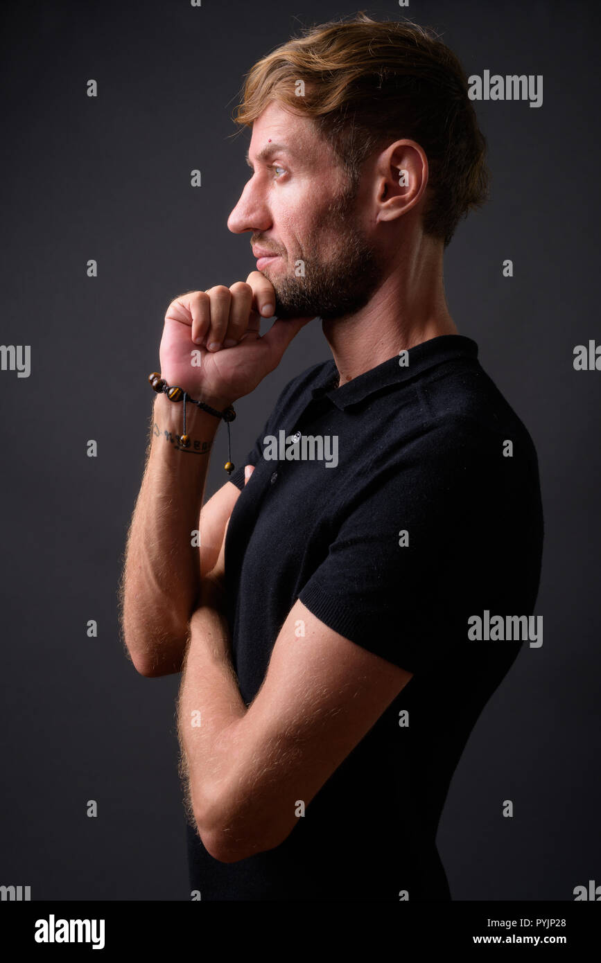 Portrait d'homme barbu blond contre l'arrière-plan gris Banque D'Images