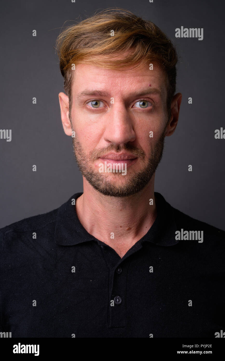Portrait d'homme barbu blond contre l'arrière-plan gris Banque D'Images
