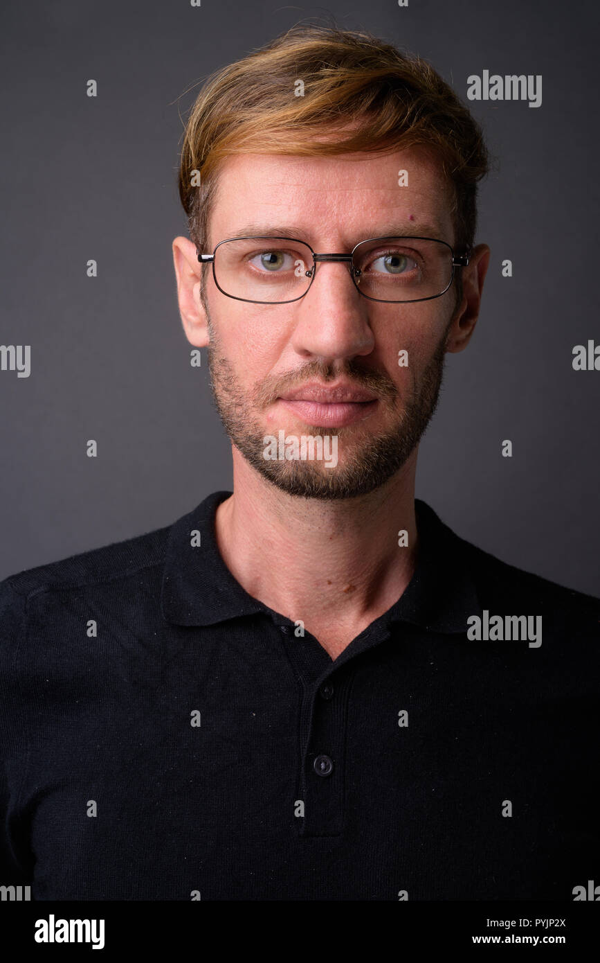 Portrait d'homme barbu blond contre l'arrière-plan gris Banque D'Images