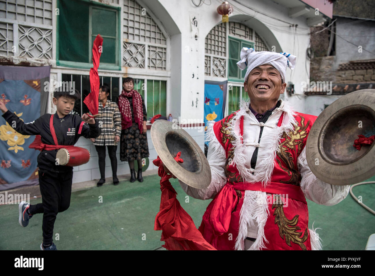 (181029) -- Yan'an, le 29 octobre 2018 (Xinhua) -- Zhou Zhifu (R) a frappé les cymbales pour aider son petit-fils apprendre la danse du tambour à la taille en Fengjiaying Village de Ansai, District de la ville de Yan'an, province du Shaanxi du nord-ouest de la Chine, le 19 octobre 2018. Ansai District, situé dans la partie nord de la province du Shaanxi, sur le Plateau de Loess, est largement connu pour son unique folk arts comme Ansai Waist Drum Dance, papier, chants folkloriques, la peinture et l'opéra. Au cours des dernières années, Ansai a fait des efforts pour stimuler le tourisme culturel en intégrant le tourisme avec ces arts populaires unique afin d'aider à l'éradication de la pauvreté. Après une formation, peopl Banque D'Images