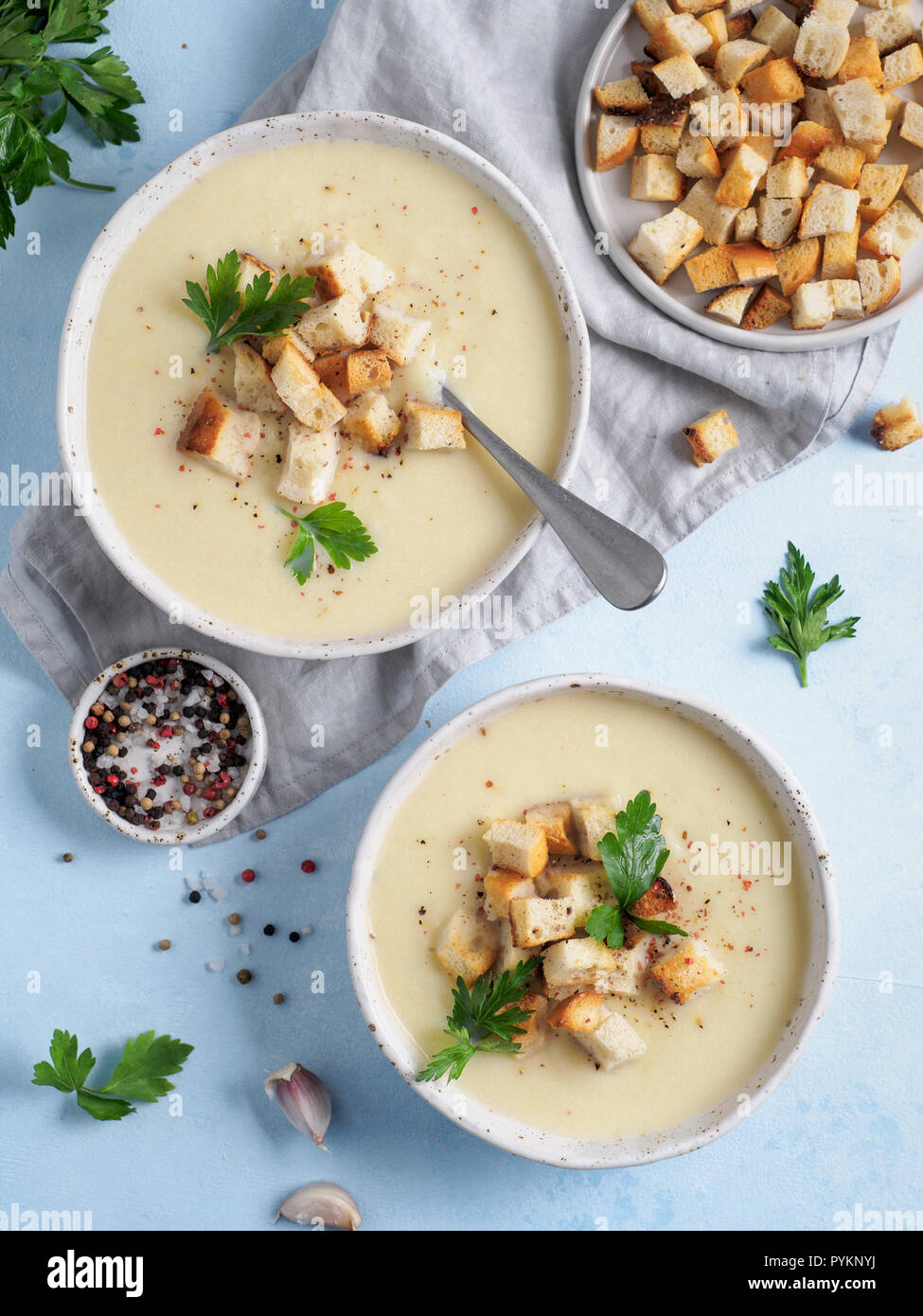 Purée de chou-fleur soupe de pommes de terre de table, bleu sur la soupe de chou-fleur crémeux avec des croûtons de pain grillé. Aliments sains végétariens concept. Idées et recettes pour des repas d'hiver. Vue supérieure ou télévision lay Banque D'Images Purée de chou-fleur soupe de pommes de terre de table, bleu sur la soupe de chou-fleur crémeux avec des croûtons de pain grillé. Aliments sains végétariens concept. Idées et recettes pour des repas d'hiver. Vue supérieure ou télévision lay Banque D'Images