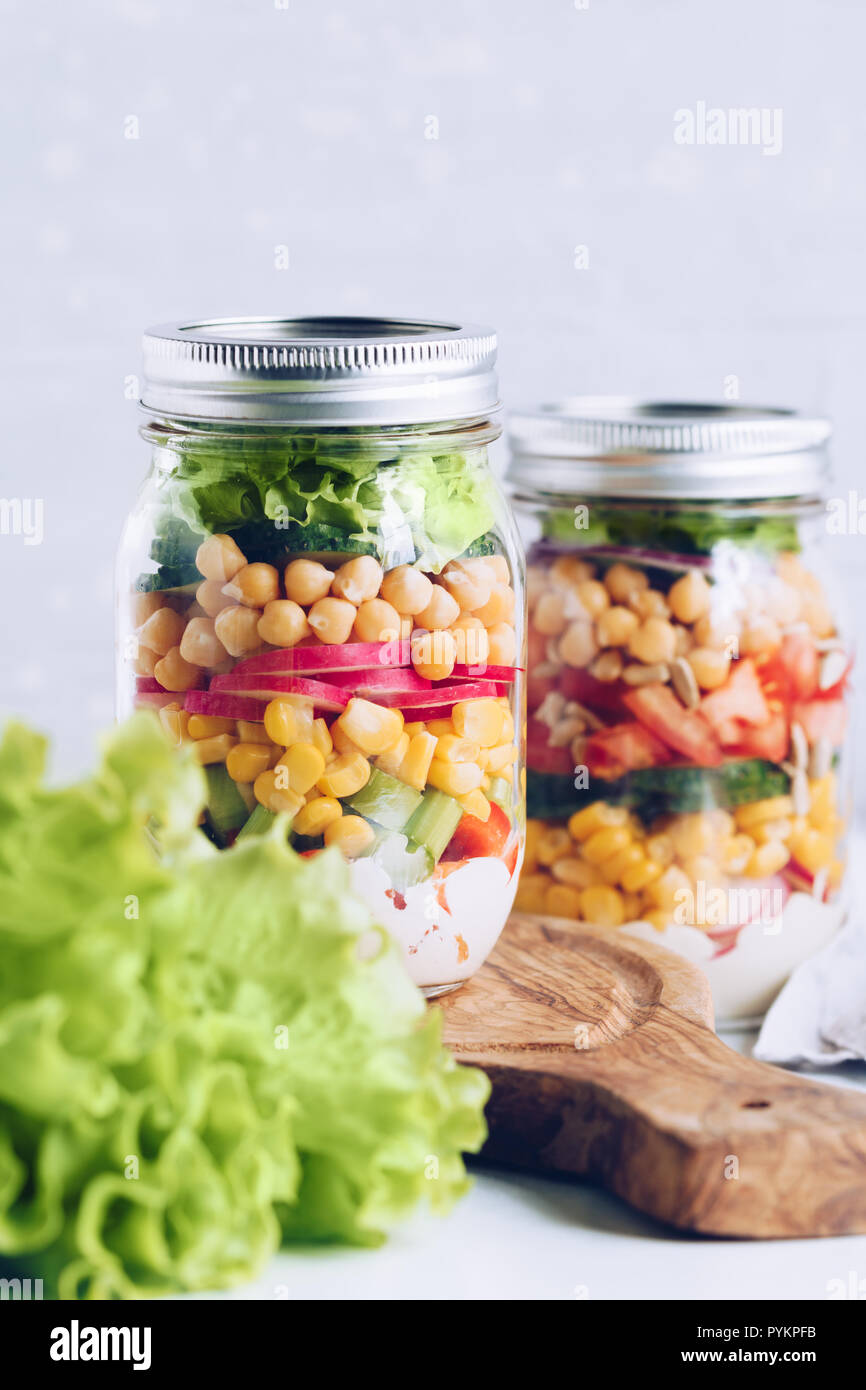 Les bocaux en verre avec la superposition vegan salade pour le déjeuner ou  le dîner. Le concept de la remise en forme, bonne hygiène de vie et la  nourriture végétarienne Photo Stock -