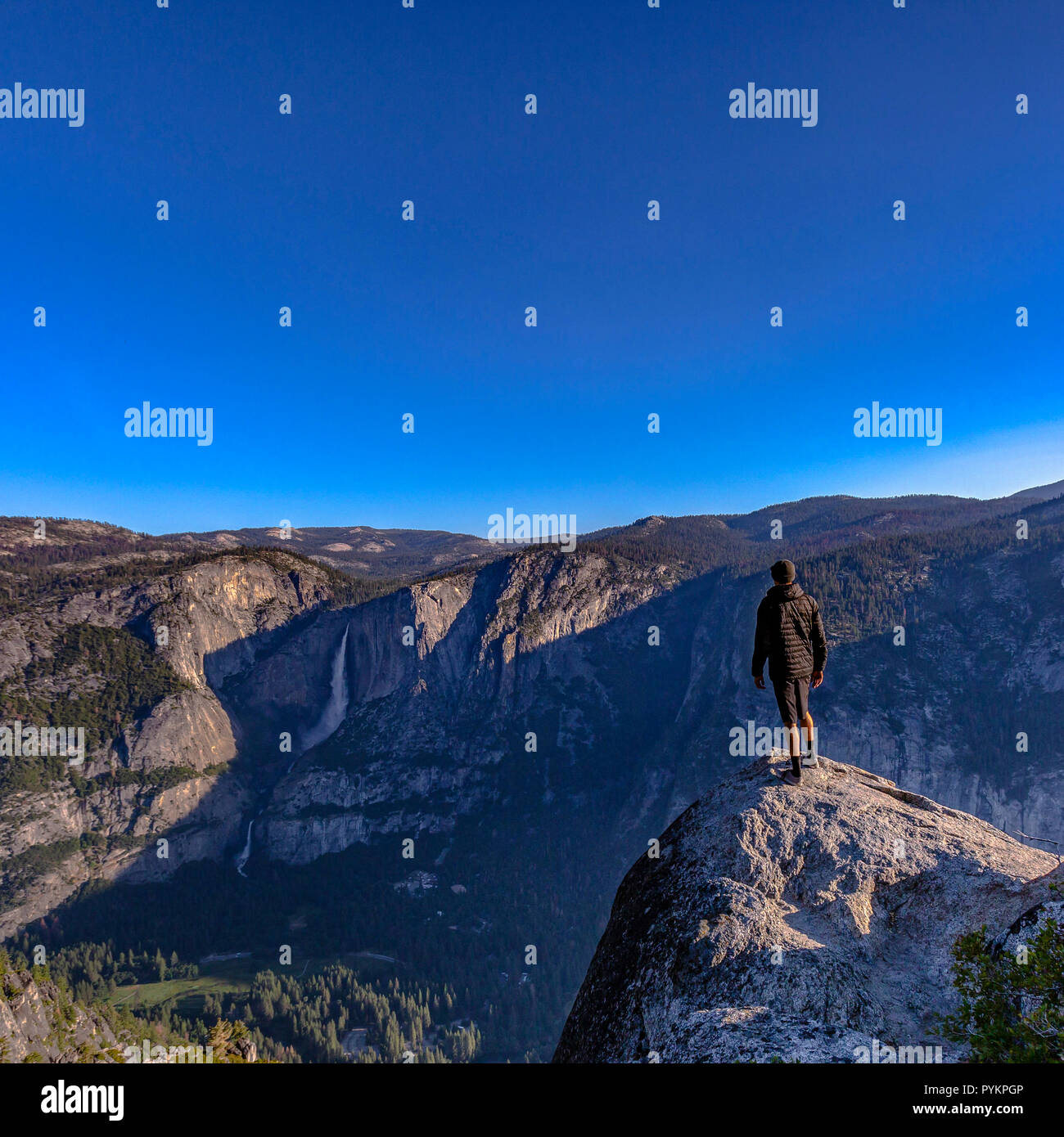 Homme debout sur la falaise avec vue sur le parc Yosemite Falls Banque D'Images