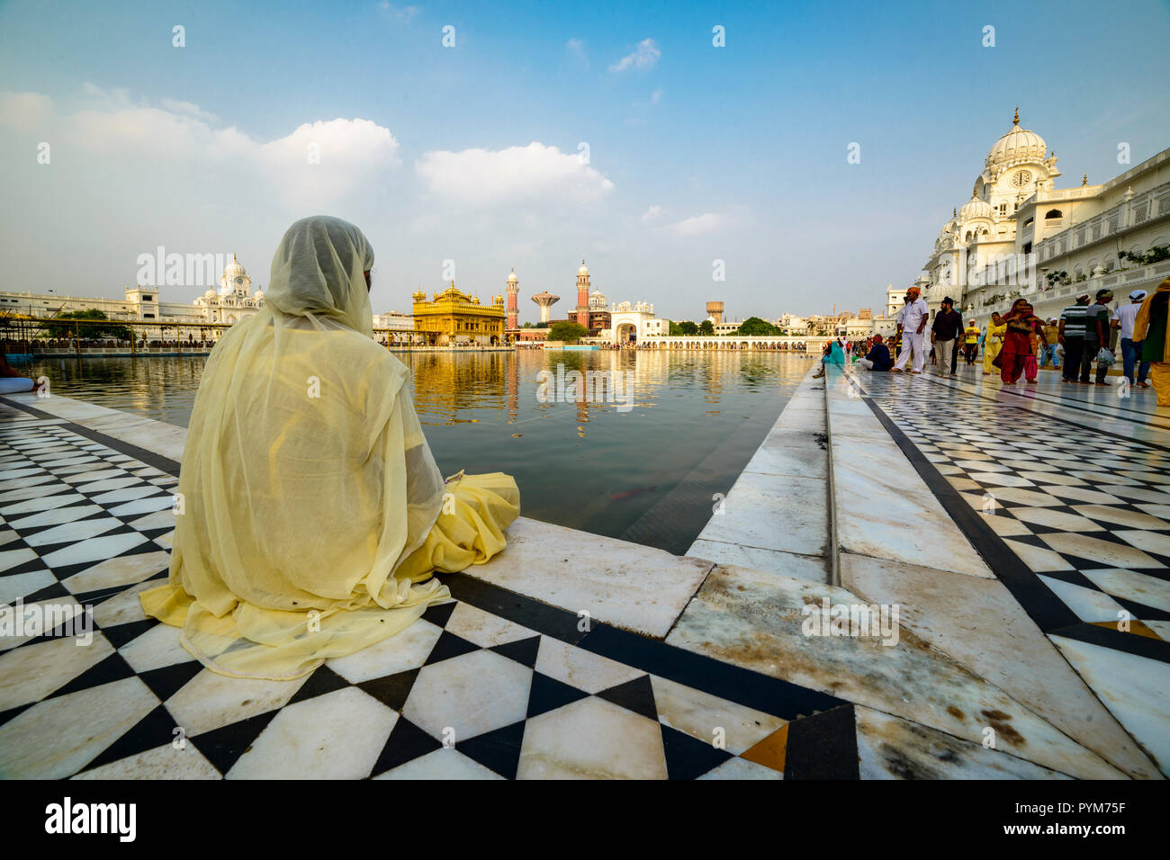 Un dévot Sikh est assis et méditant à la piscine saint du Harmandir Sahib, le Temple d'Or Banque D'Images