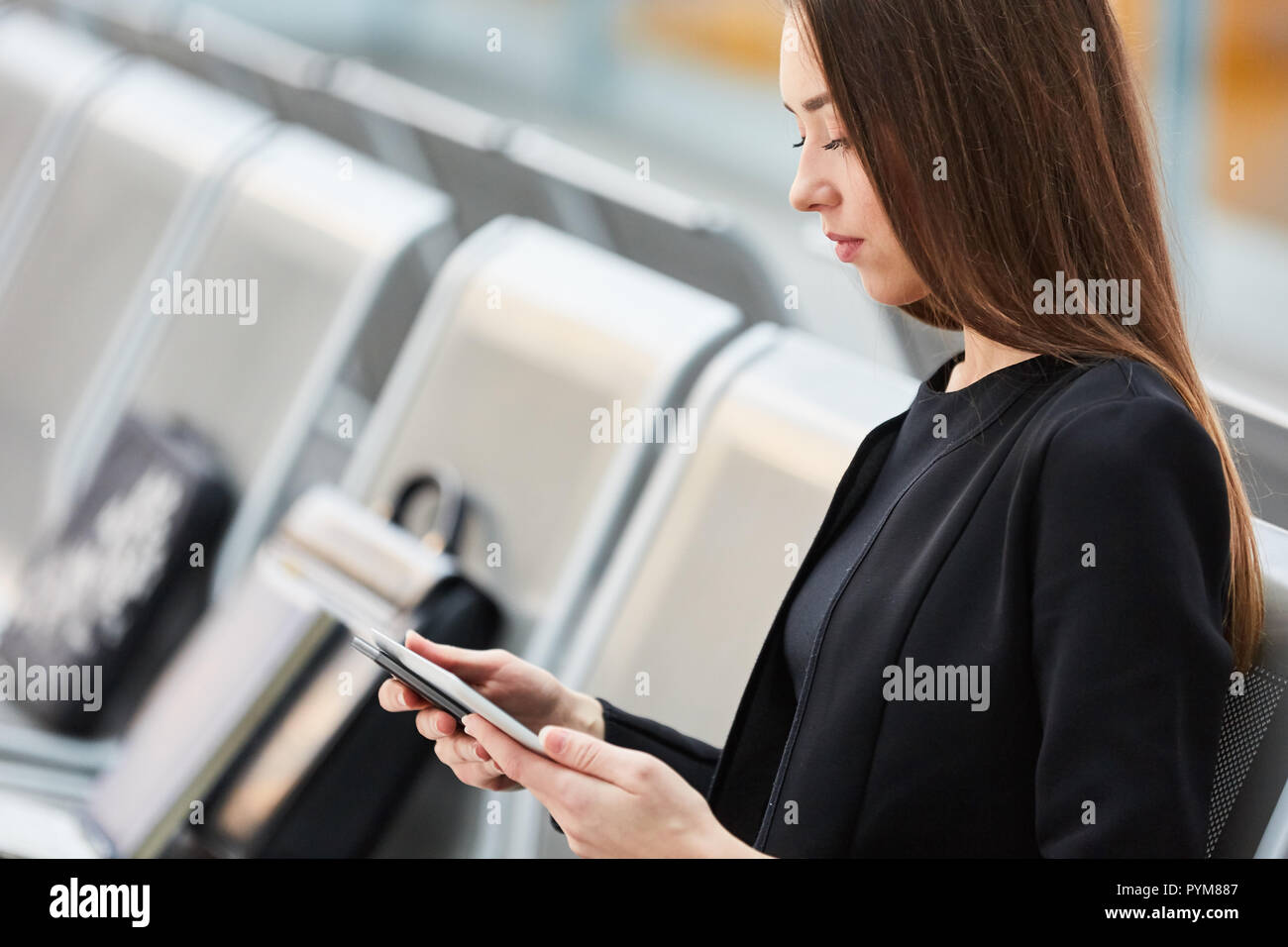 Jeune femme d'affaires avec un ordinateur tablette dans l'aire de repos dans l'aéroport en voyage d'affaires Banque D'Images