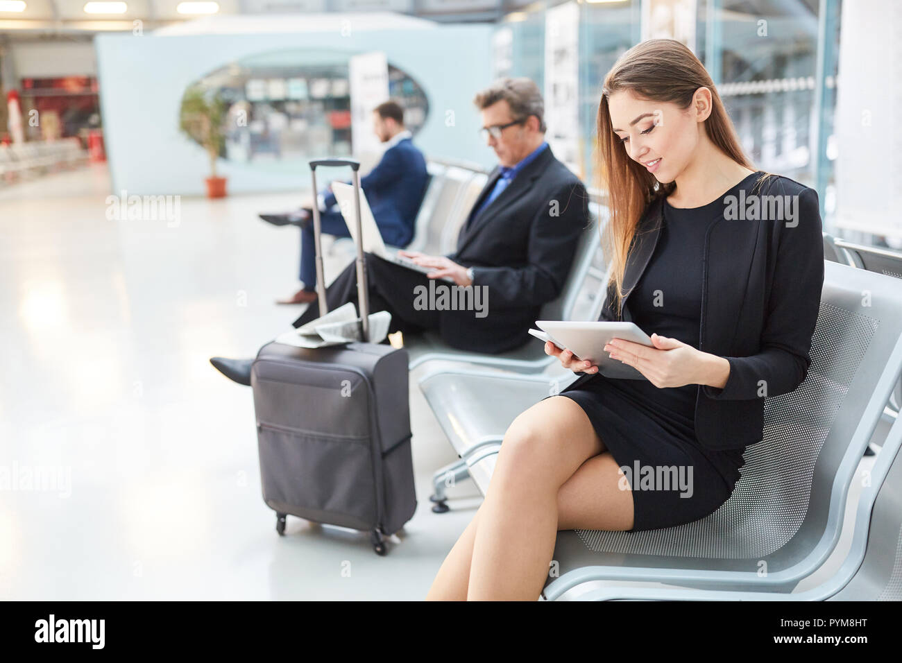 Business Woman in airport waiting area en voyage d'affaires à l'aide en ligne de l'ordinateur tablette Banque D'Images